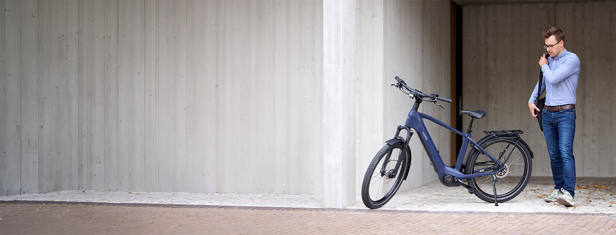 Man stapt naar zijn Steel Blue elektrische fiets. Hij gaat vertrekken naar zijn werk.